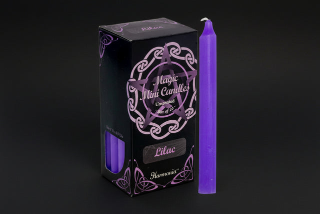 Purple candle next to its packaging with 'Harmonia' branding on a white background