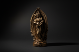 Bronze statue of a deity on a black background