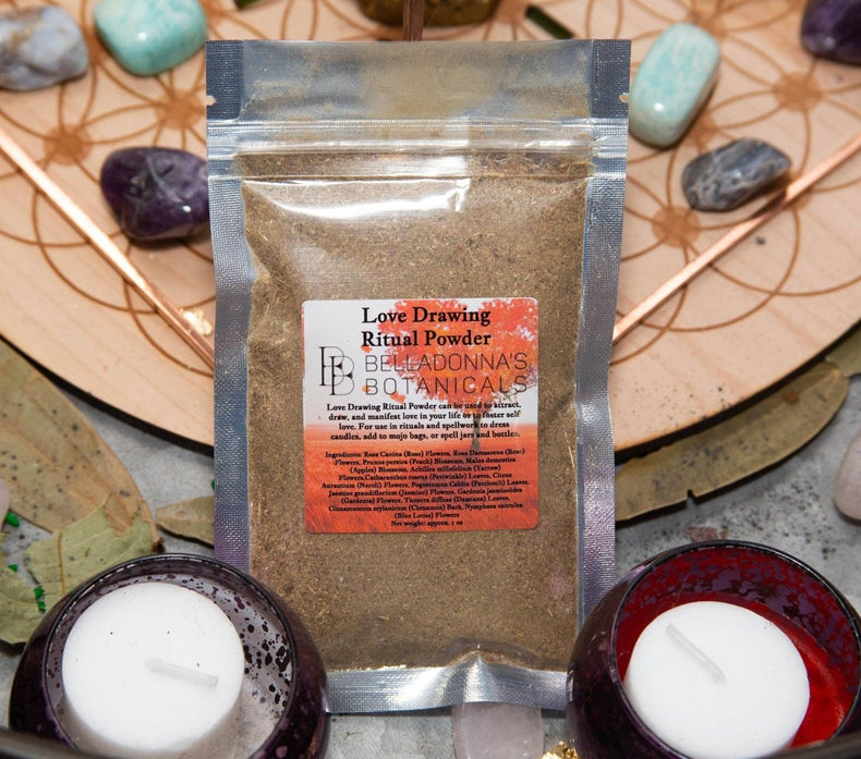 Love drawing ritual powder on a desk with occult items