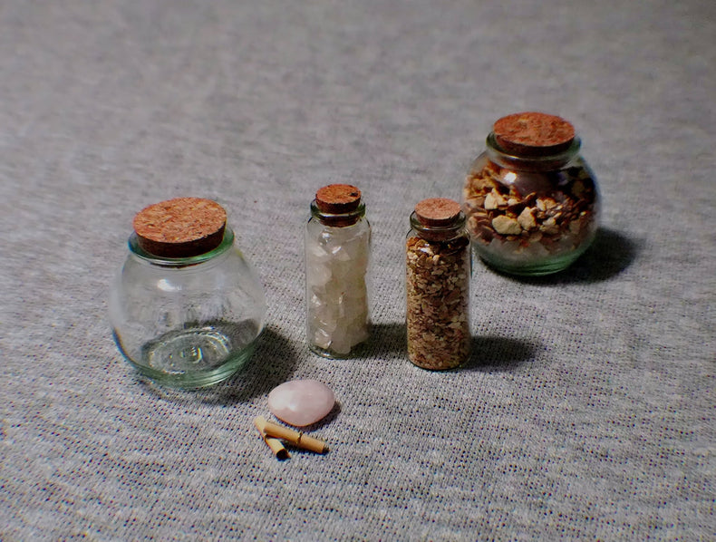 Set of small glass jars with cork lids on a textured surface