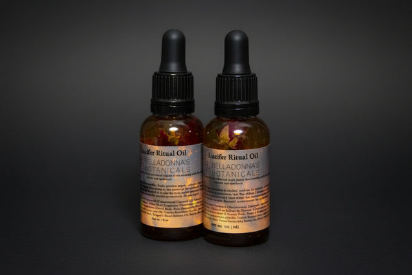 Two bottles of Locifer Ritual Oil with botanicals on a dark background