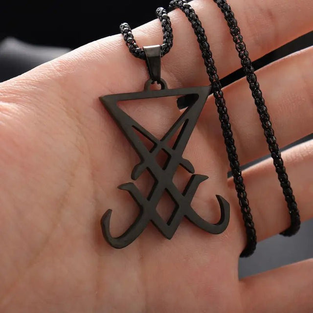 Black triangular pendant with braided chain on a hand