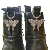 Pair of silver-tone lunar moth boot charms clipped to black boots