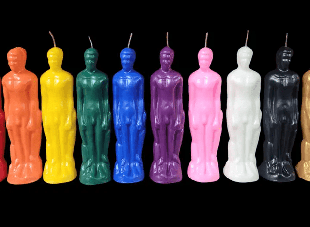 Colorful candle figurines arranged in a row against a black background