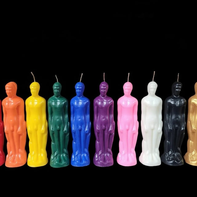 Colorful statue-shaped candles arranged in a row on a black background