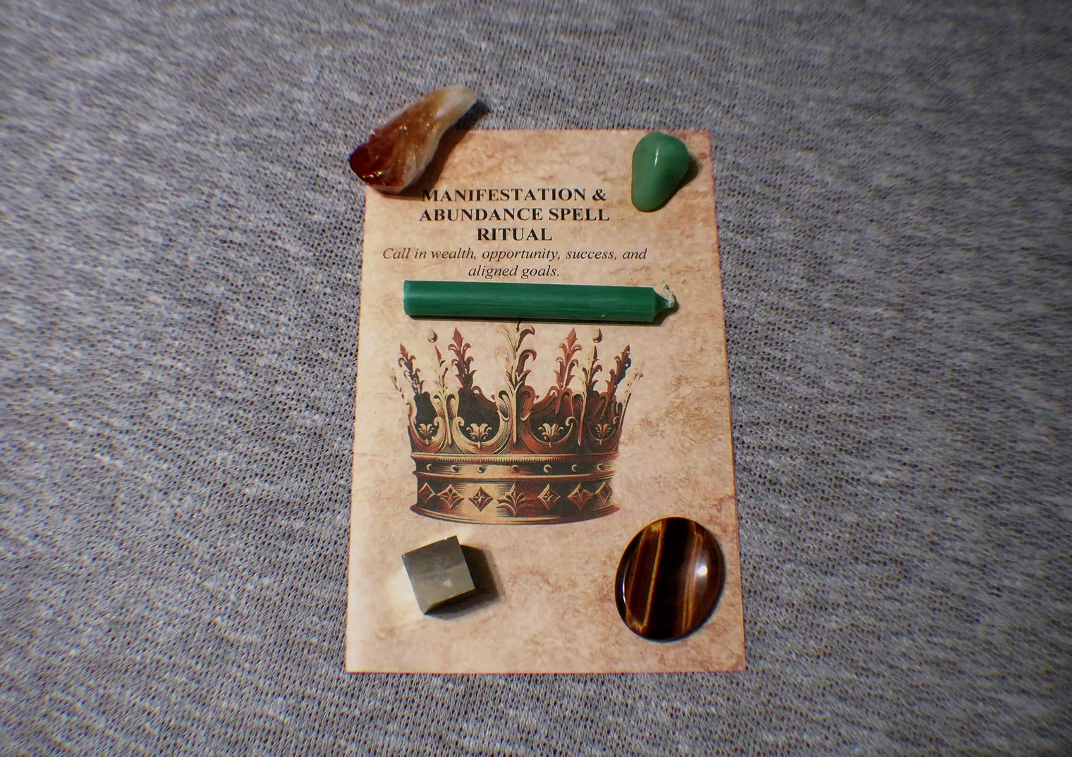 Set of stones and a card with 'Manifestation & Abundance Spell' on a gray surface