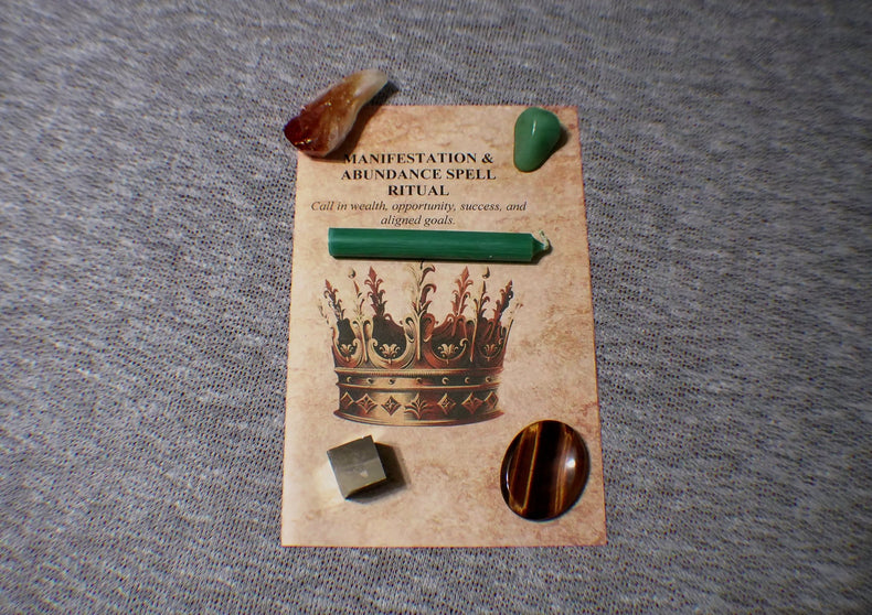 Set of stones and a card with 'Manifestation & Abundance Spell' on a gray surface