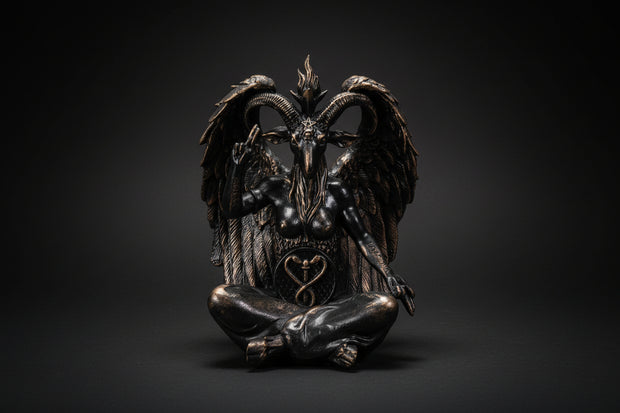 Bronze statue of a winged creature with a heart symbol on a white background
