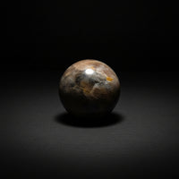 Polished dark Moonstone sphere with brown, gray, and yellow-orange patterning
