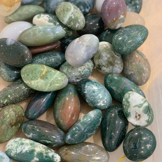Assorted green and brown marbled stones on a light background
