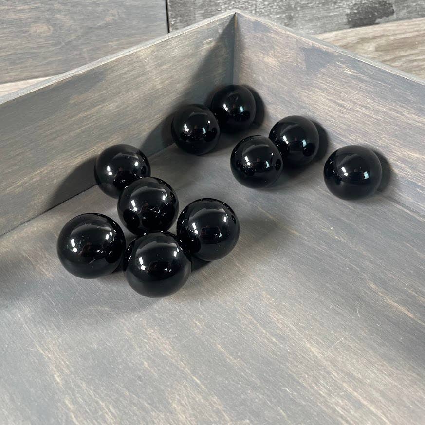 Black spherical objects on a wooden surface