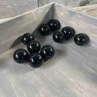 Black spherical objects on a wooden surface