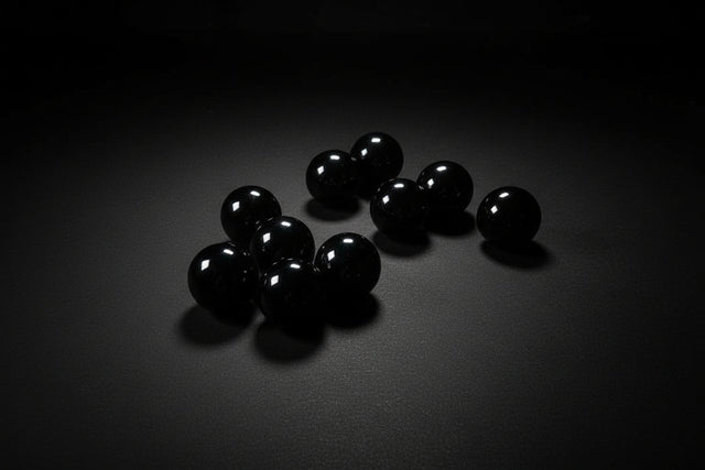 Black spherical objects on a wooden surface