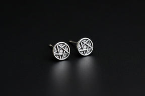 Black earring holder shaped like a face with an earring on a blurred background