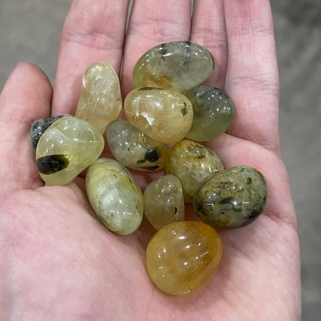 Hand holding a collection of translucent stones with a blurred background
