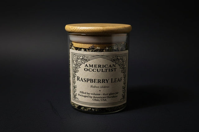 Dried cut-and-sifted raspberry leaf (Rubus idaeus) in a labeled glass ritual herb jar