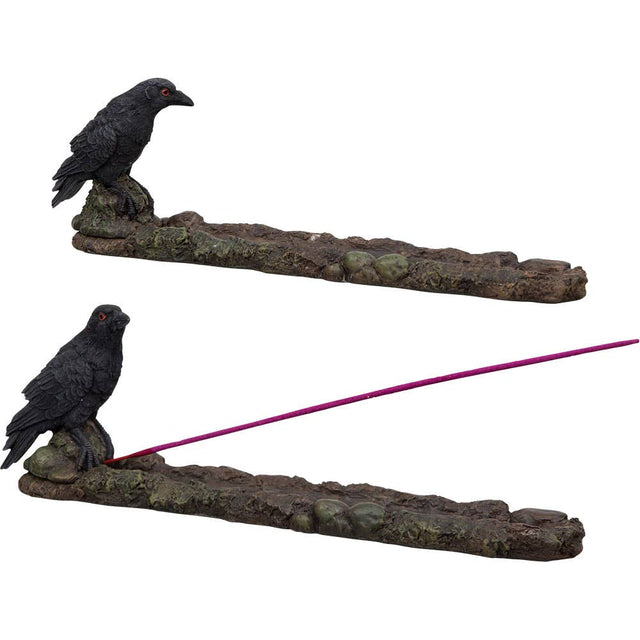Incense burner with two black bird figurines and a purple incense stick on a white background