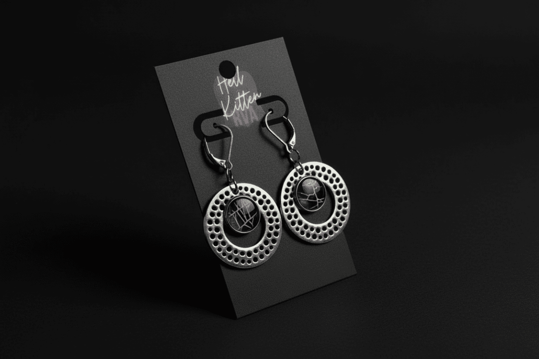 Silver-tone circle earrings containing preserved real spiderweb