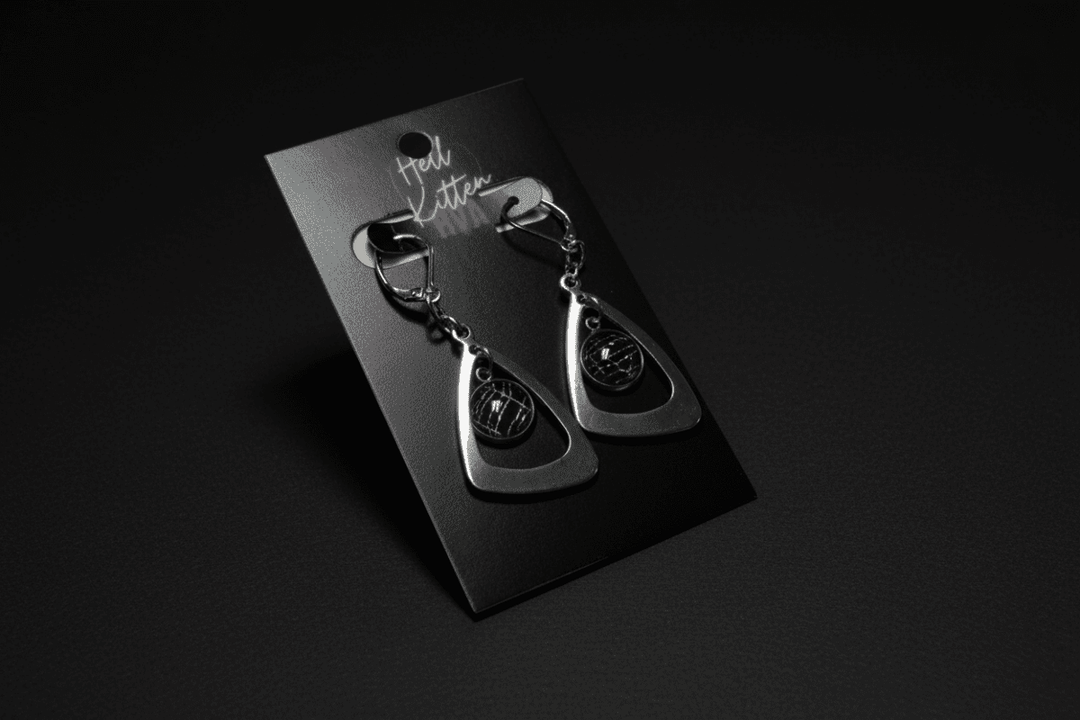 Silver-tone teardrop earrings containing preserved real spiderweb