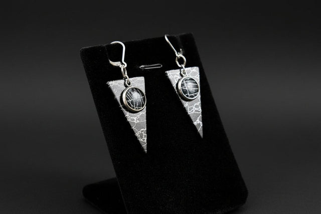 Triangle earrings containing preserved natural spiderweb