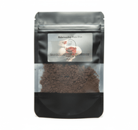 Black coffee bag with visible coffee grounds and a label on a white background