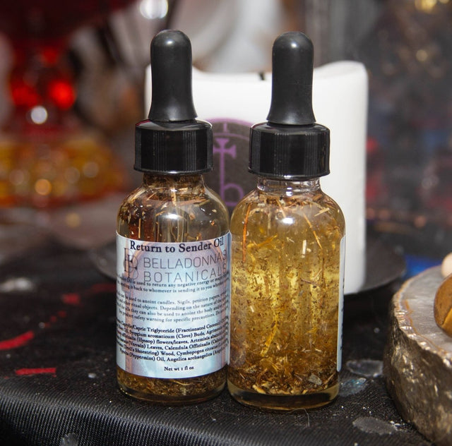Two dropper bottles of Belladonna Botanicals oil on a dark surface with a blurred background.