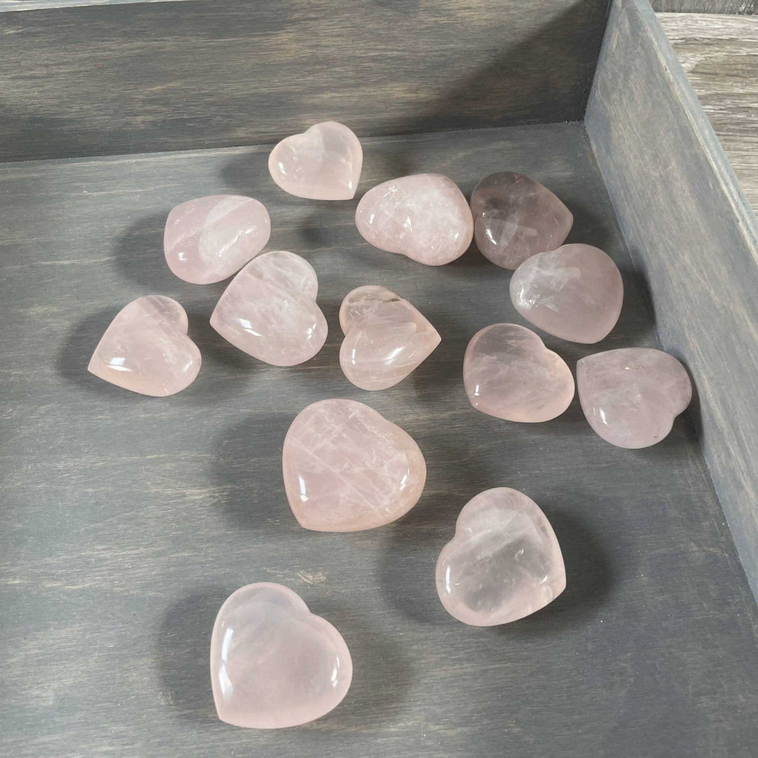 Heart-shaped rose quartz crystals on a wooden surface