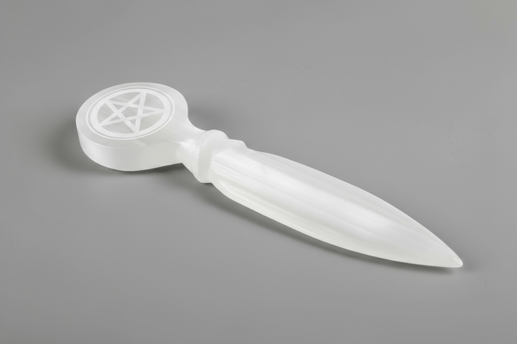 white selenite athame with a pentacle etched into the handle on a gray background.