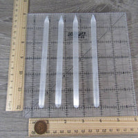 Clear crystal sticks on a ruler for measurement on a wooden surface