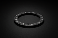 Black circular object with embossed letters on a black background