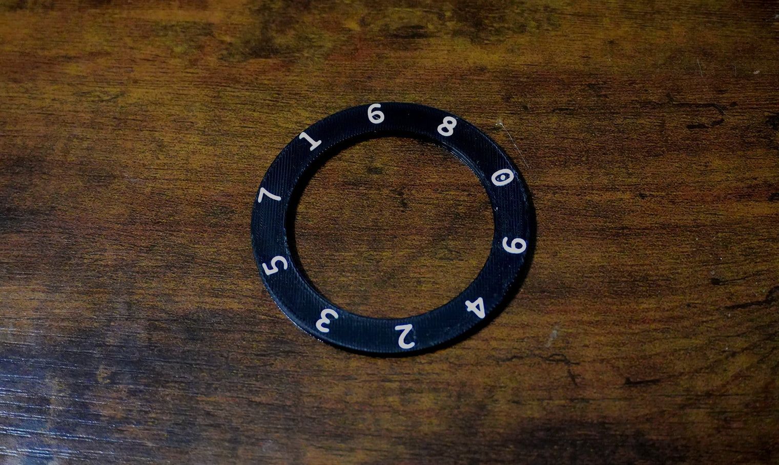Black ring with numbers on a wooden surface