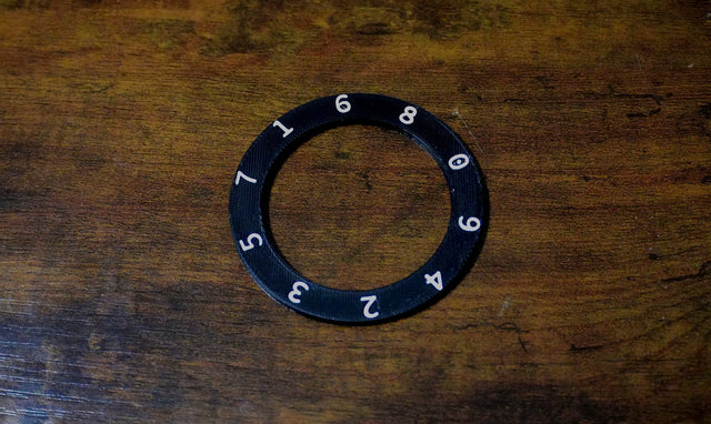 Black ring with numbers on a wooden surface