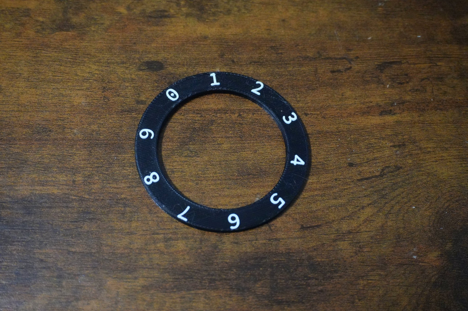 Black ring with numbers on a wooden surface