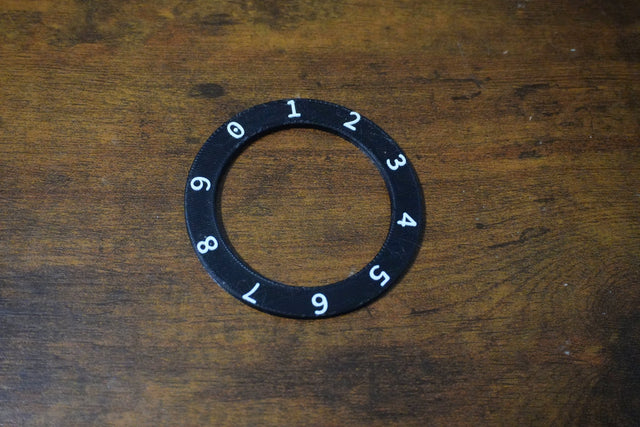 Black ring with numbers on a wooden surface