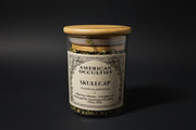 Organic dried cut-and-sifted skullcap aerial parts (Scutellaria lateriflora) in a labeled glass ritual herb jar