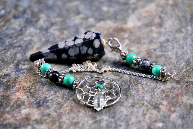 Necklace with turquoise and black beads on a textured surface