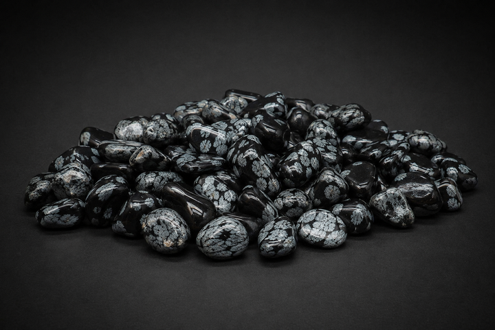 Pile of polished black Snowflake Obsidian tumbled stones with gray-white cristobalite patterns on black