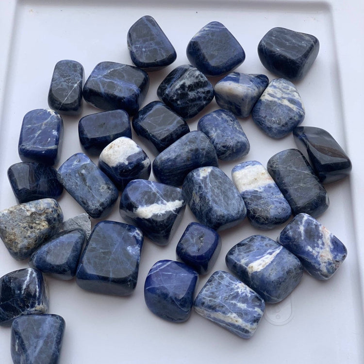 Collection of blue and gray stones on a white surface