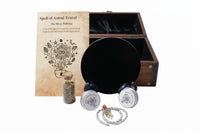 Magical spell kit with book, obsidian mirror, and other items on a gray surface