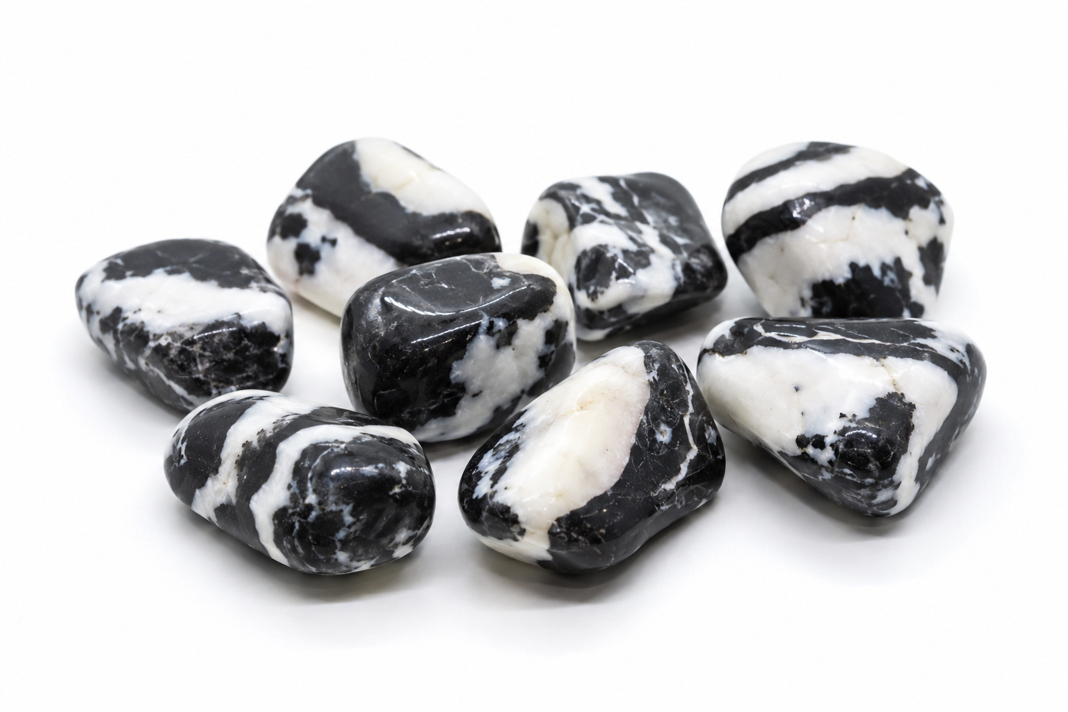 Assortment of polished Tiger Calcite stones with black, white, and cream banding on white