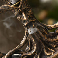 Bronze sculpture of a face with intricate detailing on a blurred background