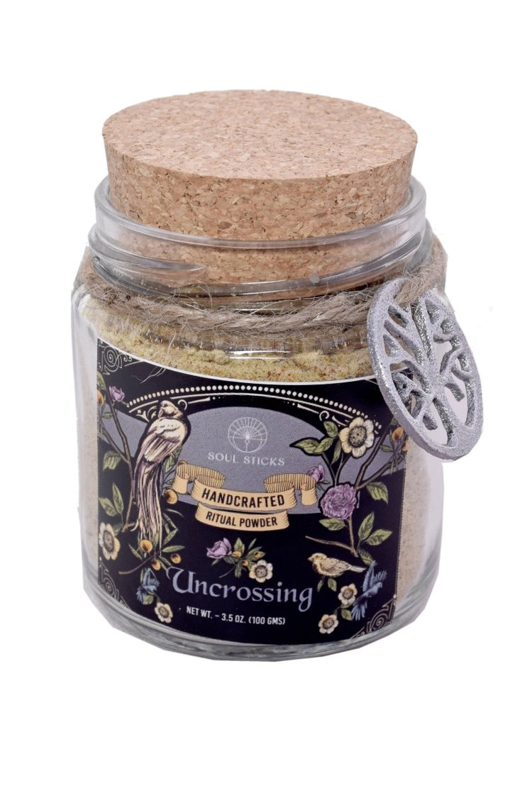 Glass jar with a ritual powder and cork lid and decorative label on a white background