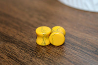 Three yellow stones with green veins on a wooden surface