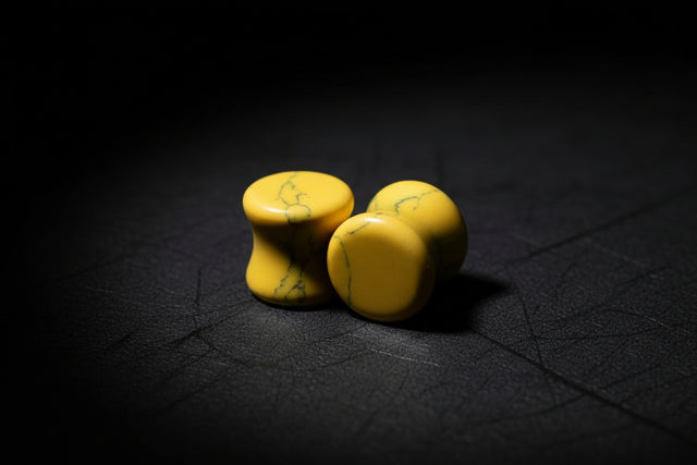 Three yellow stones with green veins on a wooden surface